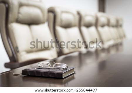 Closeup of notebook on table in empty corporate conference room before business meeting in office