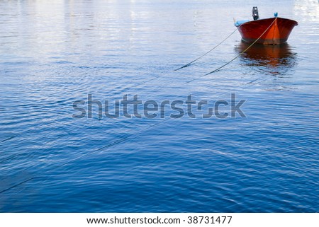 Red fishing boat in a sea blue.