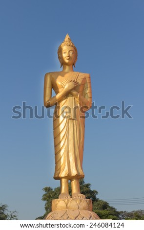 Golden Buddha standing and touching the chest.