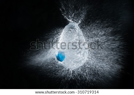 popping water balloon releases fine water strands and keeps its original shape / highspeed image
