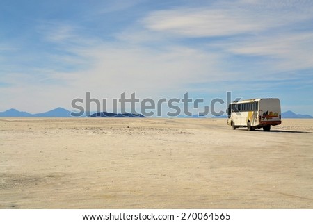 Salar Uyuni, Bolivia - 26 November 2012: A tourist bus drives through Salar Uyuni. A Jeep Tour through the Bolivian Salt Desert Uyuni is a popular touristic activity on the Altiplano in Bolivia