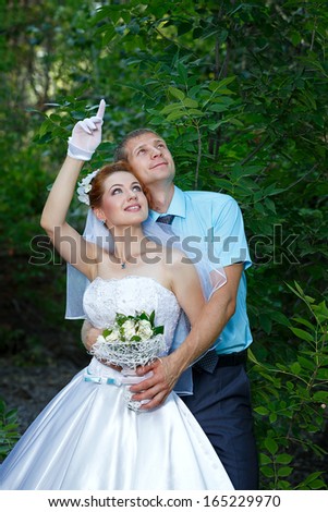 Happy Newlyweds Strolling in a City Park in Summer