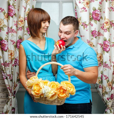 An attractive young couple. Girl feeding her boyfriend ripe apple