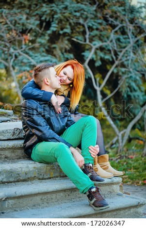 Attractive young couple sitting on the steps and hugging each other