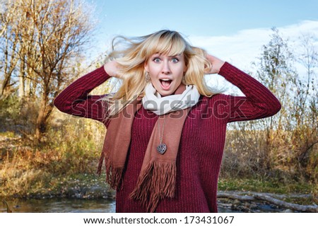 Attractive young blonde girl ruffled hair, shot in a sunny day outdoors