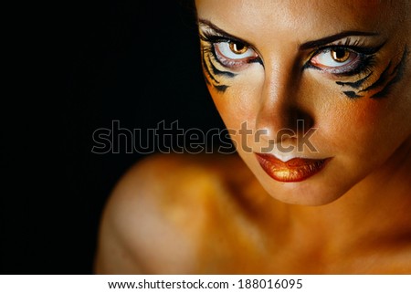 Beautiful and dangerous girl tigress with predatory gaze close-up portrait