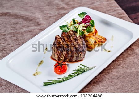 Steak with garnish in a restaurant on a white plate closeup shot