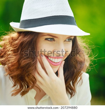 Portrait of a young attractive girl in a hat sunny summer day in the park