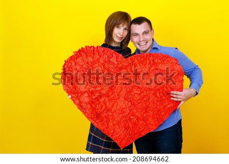 Young couple man and woman holding in hand heart for Valentine\'s day shot in the studio