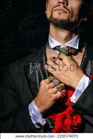 The young man is wizard corrects scarf and jewelry before performance