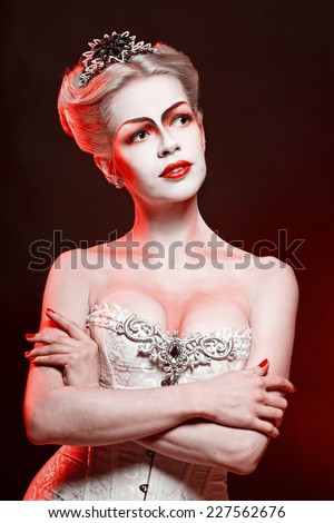 Red Queen with a crown and a corset, with make-up in studio shot