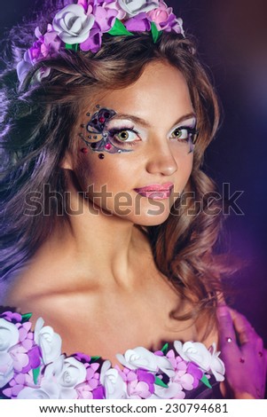 Young attractive girl with an unusual make-up and flower wreath