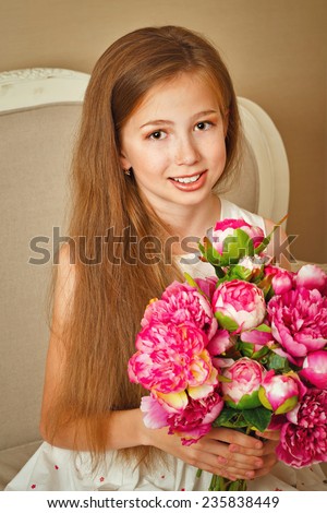 Little cute girl with doll appearance dressed in a beautiful dress. Flowers