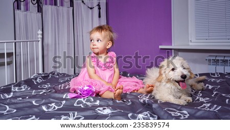 Little cute girl and dog in home interior