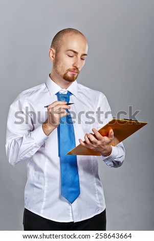 Businessman in shirt and tie pen writes in a folder with papers. Business people. Concept of success.