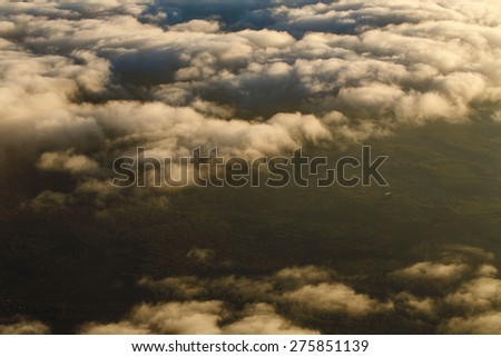 View of clouds from the window of a jet aircraft. Flying above the clouds. Clouds at sunset. Concept travel.