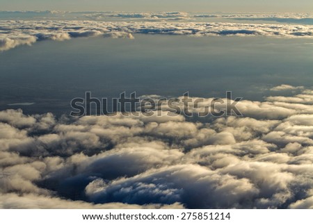 View of clouds from the window of a jet aircraft. Flying above the clouds. Clouds at sunset. Concept travel.