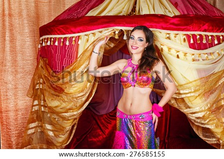 Sexy oriental beauty dancing belly dance in front of the tent. The concept of the Arab harem.
