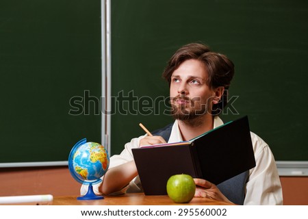 Man geography teacher thinks, holding a notebook. Back to school.