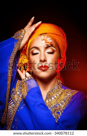 Portrait of oriental beauty with face art and national costumes. Girl dressed in jellabiya and Khaleej. Face art sun and camels. Girl with makeup. The concept of Oriental fashion.
