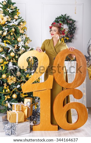 The girl standing next to Xmas 2016. hairstyle. Young happy. New Year party. Merry Christmas.