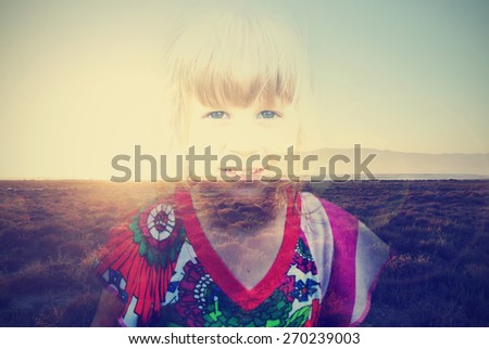 Double exposure image of a little smiling blonde girl and summer sunset. Image filtered in faded, washed out, retro, vintage style, with vignette and lens flare.