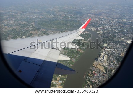 Wing of an airplane flying above the clouds. people looks at the sky from the window of the plane, using airtransport to travel.