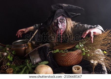 Witches bends over a table with witches ingredients