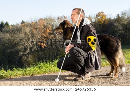 A blind man on a walk with his assistance dog