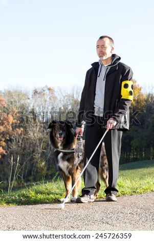 A blind man goes for a walk with his guide dog
