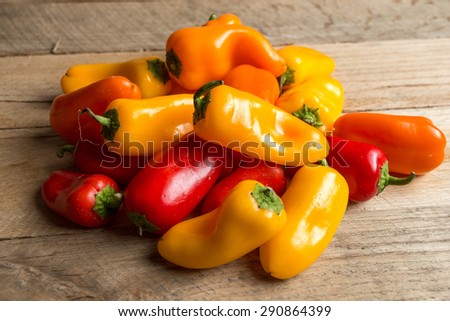 Bunch of red, yellow, and orange bell peppers on weathered wood background. of red, yellow, and orange bell peppers on weathered wood background.