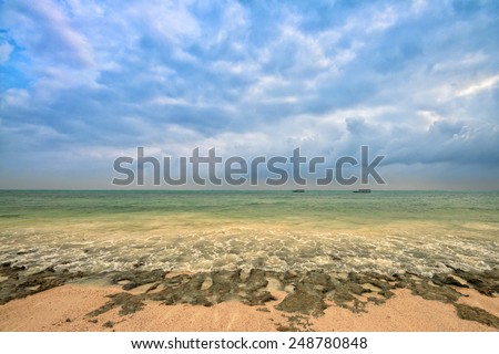 Tropical beach during the tide with sand, sky and littoral zone