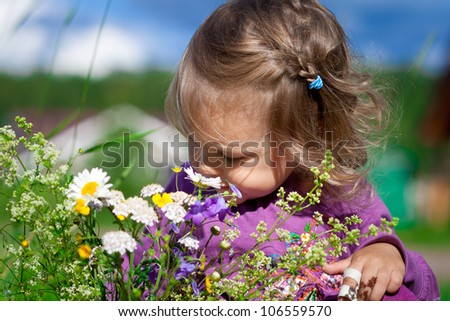 Cute baby girl smells flowers