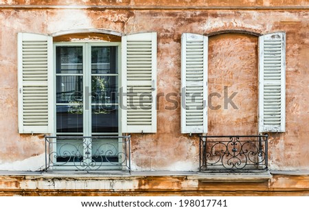 Two old shutters on a window and a wall built to mask a window. Decoration on an old French building.