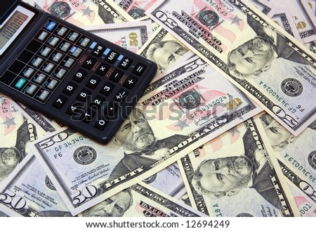The calculator atop of dollar banknotes for backrounds and other.\
\
See more finance concepts by keyword \