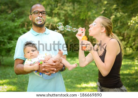 Happy interracial family is blowing bubbles