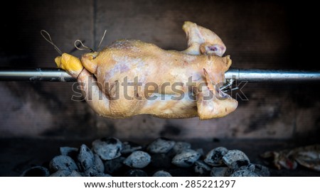 Cooking raw rotisserie chicken on the grill with Charcoal and Briquettes in the professional steak house or barbecue restaurant