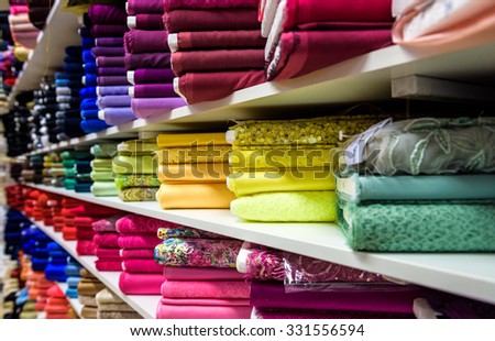 Rolls of fabric and textiles in a factory shop or  store or bazar. Multi different colors and patterns on the market. Industrial fabrics.