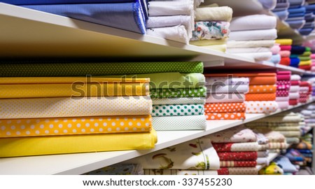 Rolls of fabric and textiles in a factory shop or  store or bazar. Multi different colors and patterns on the market. Industrial fabrics.