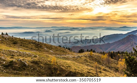 Sunset in the mountains. View of the valley. Golden hour yellow dusk or dawn with sun sunset or sunrise.