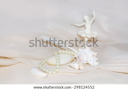 Vintage composition with  ballerina, pearls, shellfish, white sea stone and feather