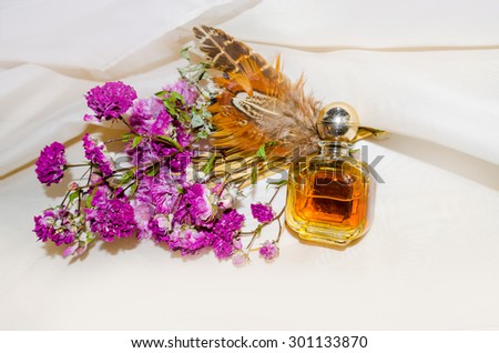Vintage Perfume Bottle with dry roses and brown feathers