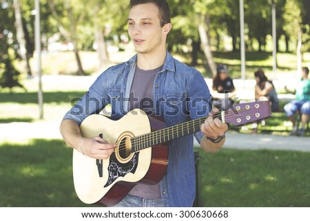 The guy is learning to play guitar, outdoor