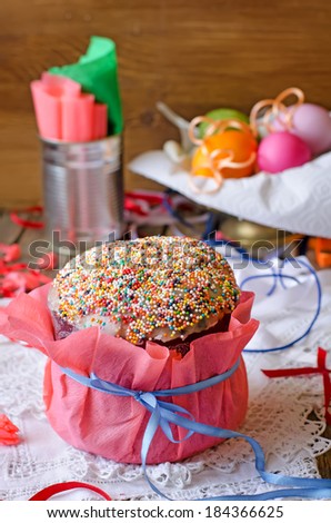 Easter cake and eggs on the white cloth with colorful ribbons. focus on the blue ribbon bow