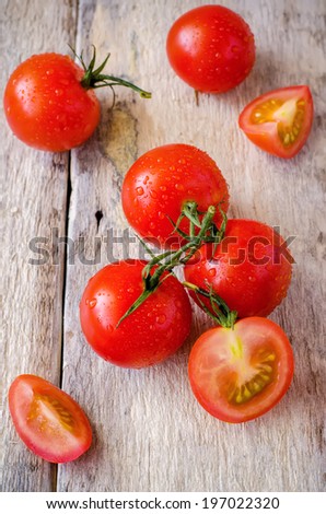 red cherry tomatoes on a white wood background. toning. selective focus to the top of tomato