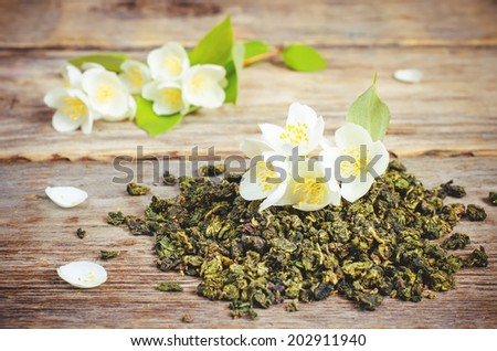 Jasmine tea on a dark wood background. toning. selective focus on the jasmine flower.