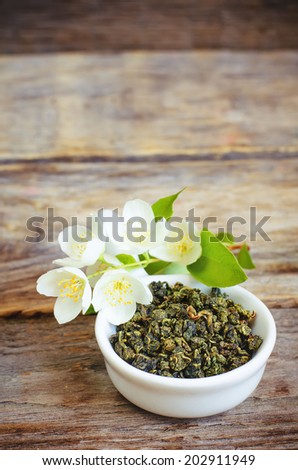 Jasmine tea on a dark wood background. toning. selective focus on the lower jasmine flower.