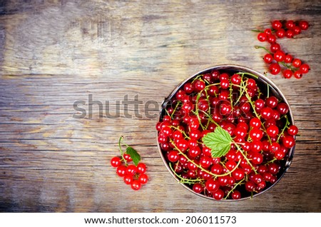 red currants on a dark wood background. toning. selective focus on leave