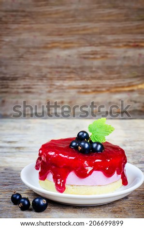 souffle cake with black currant on a dark wood background. toning. selective focus on leave