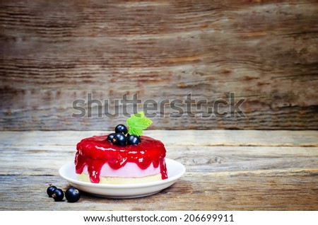 souffle cake with black currant on a dark wood background. toning. selective focus on leave